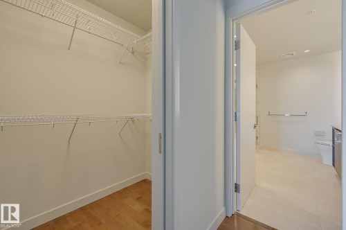 Walk-in closet with wire shelving system and wood-finish flooring - #3901 10360 102 St Nw Nw, Edmonton, AB - Indoor With Storage