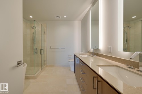 Dual vanity with integrated sinks and a stone countertop - #3901 10360 102 St Nw Nw, Edmonton, AB - Indoor Photo Showing Bathroom