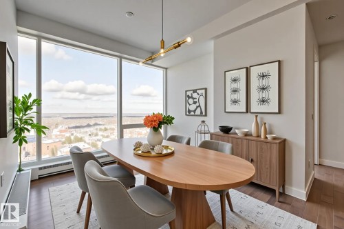 Dining area featuring expansive window walls, wood-finish flooring, and a contemporary linear chandelier - #3901 10360 102 St Nw Nw, Edmonton, AB - Indoor Photo Showing Dining Room