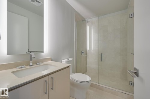 Modern bathroom featuring a vanity with an integrated sink, polished chrome faucet, and under-cabinet storage - #3901 10360 102 St Nw Nw, Edmonton, AB - Indoor Photo Showing Bathroom