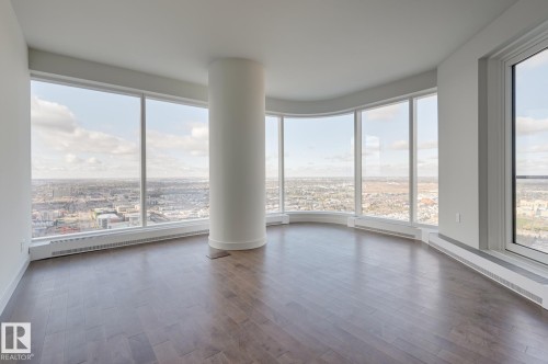 Curved wall of floor-to-ceiling windows with a cityscape backdrop - #3901 10360 102 St Nw Nw, Edmonton, AB - Indoor Photo Showing Other Room