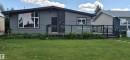 Contemporary exterior featuring horizontal siding, an angled roofline, and a prominent stone veneer accent - 10523 105 Street, Westlock, AB 