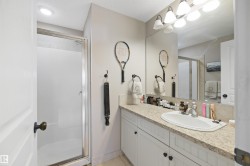 Vanity with integrated sink, speckled countertop, and white cabinetry - 