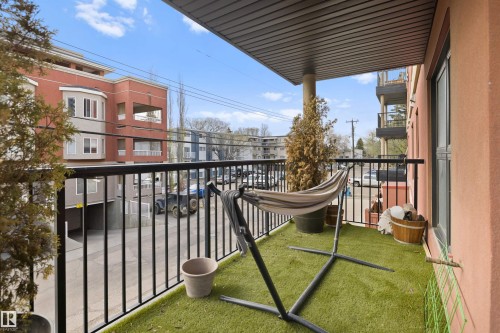 Private balcony featuring artificial turf flooring and a black metal railing - #206 10232 115 St Nw, Edmonton, AB 