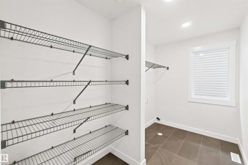 Utility room with wire shelving, recessed lighting, and a window with blinds - 2232 5 Avenue, Edmonton, AB 
