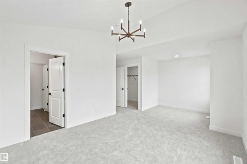 Spacious room featuring light gray carpeting and white walls - 2232 5 Avenue, Edmonton, AB 