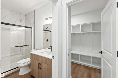 Full bathroom featuring a walk-in shower with a black-framed glass enclosure and a vanity with a white countertop - 2232 5 Avenue, Edmonton, AB 