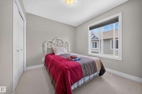 Carpeted room with a double-door closet, a single window with white trim, and light grey wall paint - 64 655 Tamarack Road, Edmonton, AB 