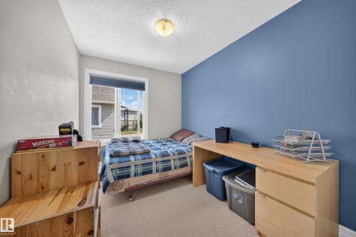 Carpeted room featuring a single window, a blue accent wall, and three light-toned walls - 64 655 Tamarack Road, Edmonton, AB 