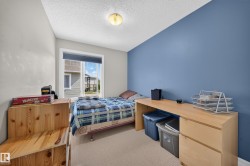 Carpeted room featuring a single window, a blue accent wall, and three light-toned walls - 