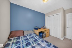 Interior room featuring a bold accent wall, neutral carpeting, and a built-in light wood-finish desk - 