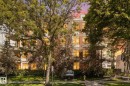 Multi-story building featuring a facade with multiple windows, some with visible balconies, and ground-level landscaping with mature trees and green lawn - 408 11140 68 Avenue, Edmonton, AB 