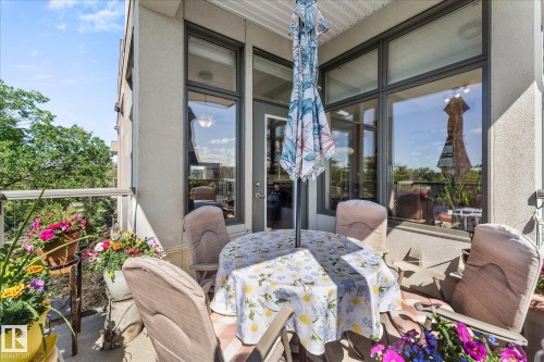 Private balcony featuring a glass and metal railing, concrete flooring, and an exterior door providing interior access - 408 11140 68 Avenue, Edmonton, AB 