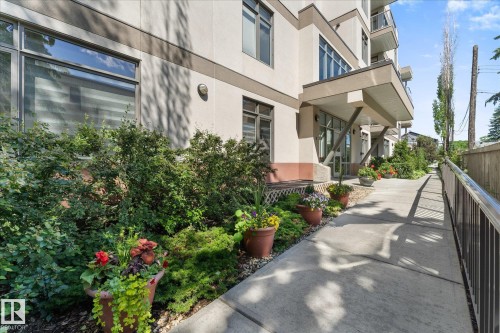 Exterior building entrance featuring a covered walkway and concrete ramp with metal railings - 408 11140 68 Avenue, Edmonton, AB 