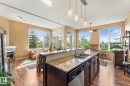Kitchen island featuring a double-basin sink, integrated dishwasher, and granite countertop - 408 11140 68 Avenue, Edmonton, AB 