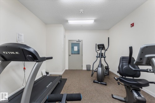 Fitness room featuring a treadmill, elliptical, and stationary bicycle - 408 11140 68 Avenue, Edmonton, AB 