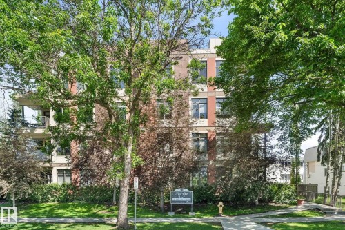 Multi-story building featuring brick and stucco exterior, multiple large windows, and private balconies with glass railings - 408 11140 68 Avenue, Edmonton, AB 