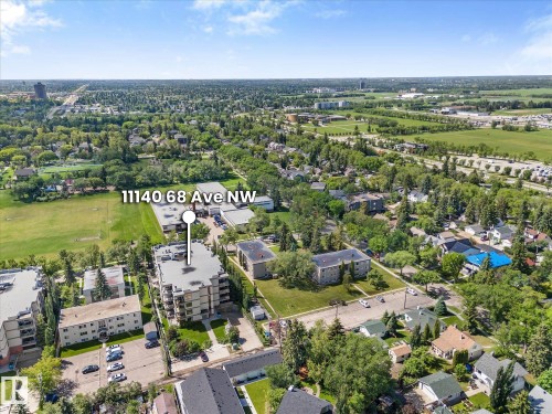 Aerial perspective showcasing a multi-story residential building with surrounding green spaces and urban infrastructure - 408 11140 68 Avenue, Edmonton, AB 