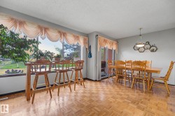 Expansive window with a built-in bar table, parquet wood-finish flooring, a sliding glass door, and a geometric wall-mounted shelving unit - 