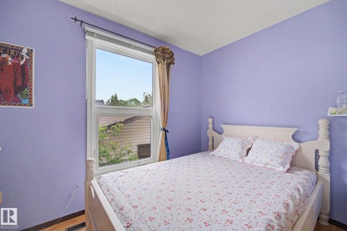 Room featuring a double-hung window, light purple walls, and wood-finish flooring - 10242 161 Street, Edmonton, AB 