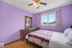 Room featuring parquet wood flooring, a ceiling fan with integrated lighting, and a large window with white trim - 