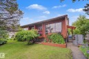 Exterior featuring wood-panel siding, prominent front windows, and a covered entry - 10242 161 Street, Edmonton, AB 
