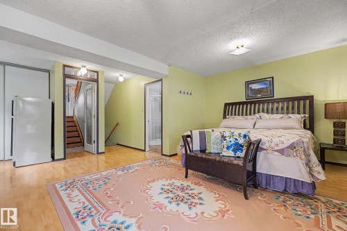 Versatile room featuring light wood-finish flooring, a wall-mounted coat rack, and recessed ceiling lighting - 10242 161 Street, Edmonton, AB 