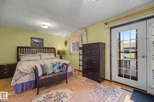 Room featuring light wood-finish flooring and direct outdoor access through double glass-paneled doors - 10242 161 Street, Edmonton, AB 