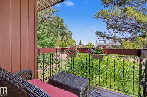Balcony with decorative iron railing, wood-finish top rail, and a slatted wall - 10242 161 Street, Edmonton, AB 