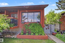 Red-hued exterior featuring a prominent picture window with decorative valance - 