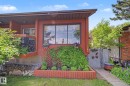 Red-hued exterior featuring a prominent picture window with decorative valance - 10242 161 Street, Edmonton, AB 