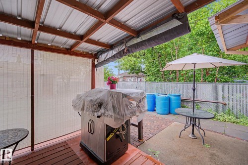 Covered patio area featuring a corrugated metal roof and exposed wooden beams - 10242 161 Street, Edmonton, AB 