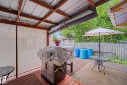 Covered patio area featuring a corrugated metal roof and exposed wooden beams - 