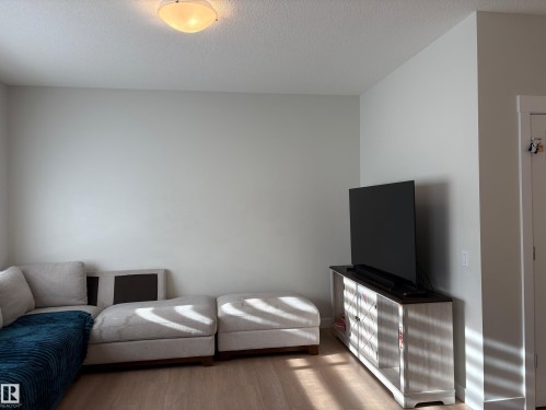 Light wood-finish flooring with neutral wall paint and a flush-mount ceiling light - 9952 227 Street, Edmonton, AB 