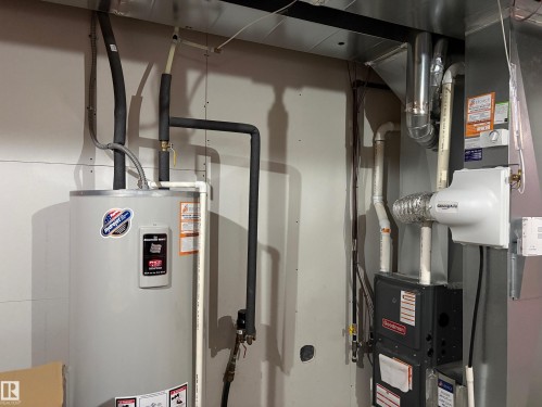 Mechanical room featuring a water heater, furnace, humidifier, and ductwork - 9952 227 Street, Edmonton, AB 
