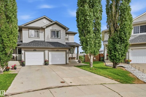 Gray siding exterior featuring a multi-gabled roof and two attached garage doors - 21207 90Ave, Edmonton, AB 