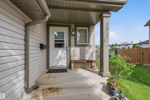 Covered front porch with concrete steps and an overhead light fixture - 21207 90Ave, Edmonton, AB 