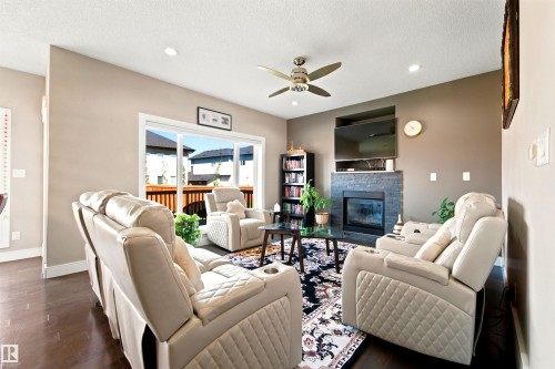 Open-concept living space featuring dark wood-finish flooring, recessed lighting, and a ceiling fan - 5110 Rue Eaglemont, Beaumont, AB 