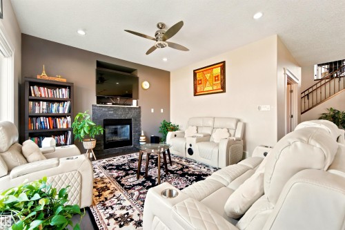 Living area featuring a floor-to-ceiling stone fireplace, recessed lighting, and a ceiling fan - 5110 Rue Eaglemont, Beaumont, AB 