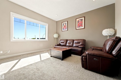 Bright living area featuring a large picture window, vaulted ceiling, and recessed lighting - 5110 Rue Eaglemont, Beaumont, AB 