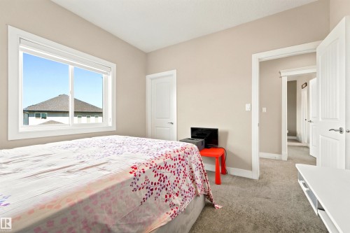 Spacious room featuring a large window, neutral wall paint, and gray carpet flooring - 5110 Rue Eaglemont, Beaumont, AB 