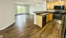 Open-concept living space featuring wood-finish flooring throughout - 318 646 Mcallister Loop, Edmonton, AB 