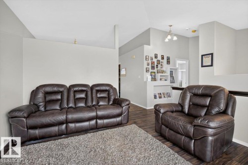 Spacious interior featuring wood-finish flooring, light gray wall paint, and a multi-tiered ceiling design - 3907 33 Street, Edmonton, AB 