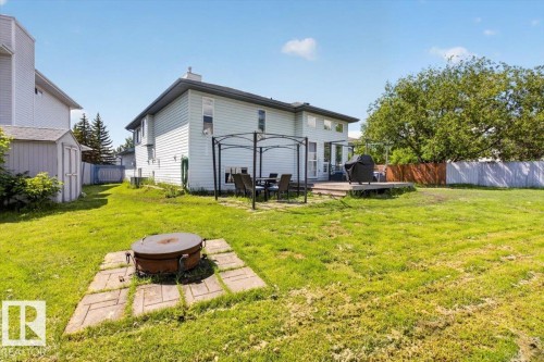 Expansive grassy backyard featuring a wooden deck, a gazebo, and a storage shed - 3907 33 Street, Edmonton, AB 
