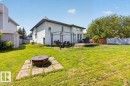 Expansive grassy backyard featuring a wooden deck, a gazebo, and a storage shed - 3907 33 Street, Edmonton, AB 