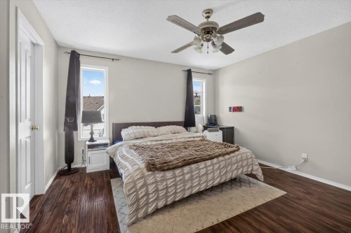 Bedroom featuring rich wood-finish flooring and a ceiling fan with integrated lighting - 3907 33 Street, Edmonton, AB 