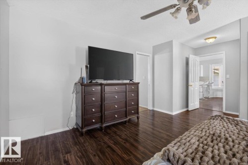 Interior room featuring wood-finish flooring, light gray wall paint, and white baseboards - 3907 33 Street, Edmonton, AB 