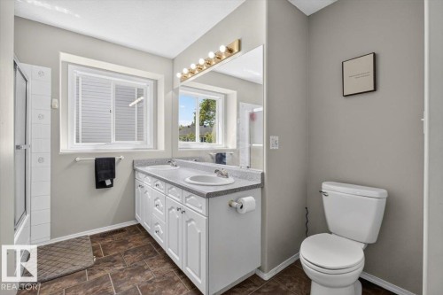 Dual sink vanity with white cabinetry and a light-toned countertop, set against neutral wall tones - 3907 33 Street, Edmonton, AB 