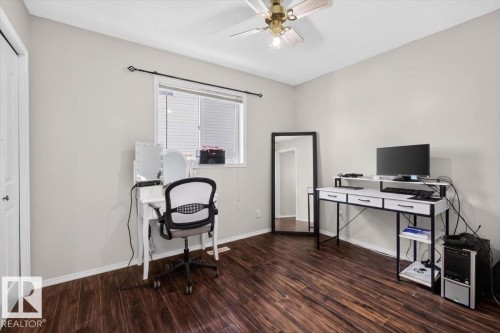 Room featuring wood-finish flooring, light grey wall paint, and a ceiling fan with integrated lighting - 3907 33 Street, Edmonton, AB 