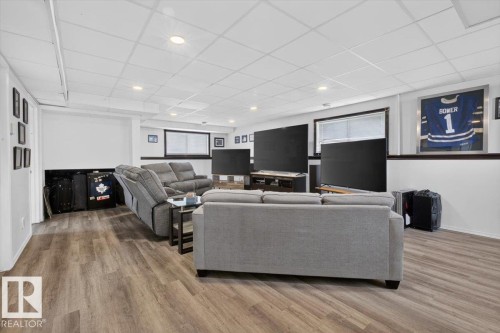 Finished basement space featuring wood-finish flooring, recessed lighting, and a drop ceiling - 3907 33 Street, Edmonton, AB 